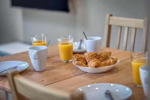 - une table avec un bol de viennoiseries et des verres de jus d'orange dans l'établissement #HG Beautiful T2 renovated in the hyper center facing train station, à Grenoble