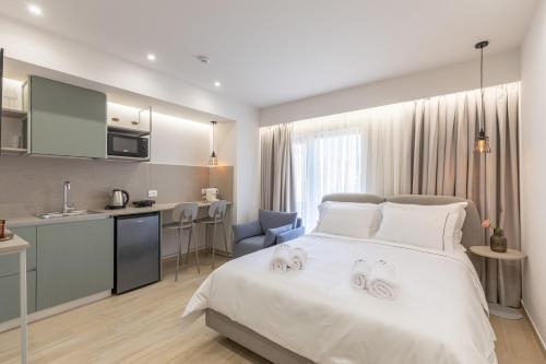 a bedroom with a white bed and a kitchen at ENeR Studios in Tirana