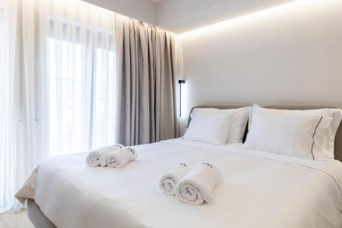 a white bed with towels on top of it at ENeR Studios in Tirana
