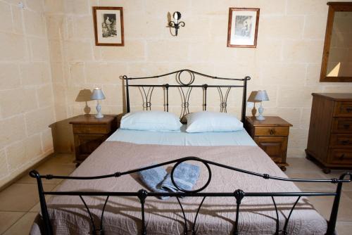 a bedroom with a black bed with two night stands at 3 Bedroom Holiday Home with Private Pool and Views in Nadur