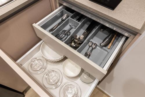 a drawer in a kitchen with glasses in it at ENeR Studios in Tirana