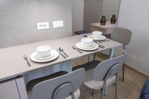 a dining room table with plates and silverware on it at ENeR Studios in Tirana