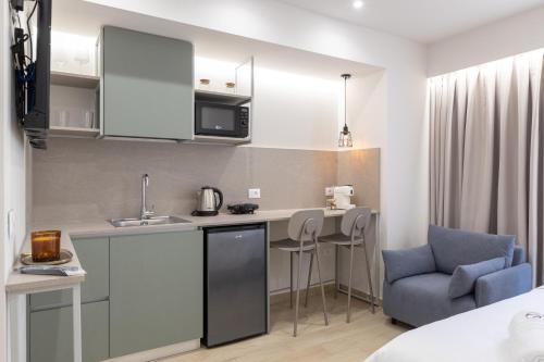 a small kitchen with a table and a blue chair at ENeR Studios in Tirana
