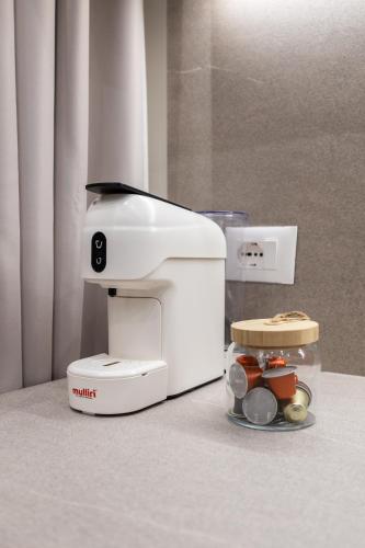 a coffee maker sitting on a counter next to a plate of food at ENeR Studios in Tirana