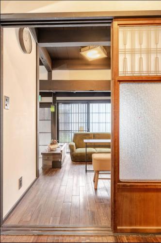 an open door into a living room with a couch at 清水寺徒歩8分 一棟貸切 伝統的な京町家 in Keage