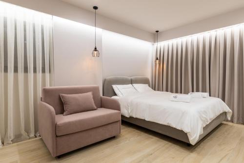 a bedroom with a bed and a chair at ENeR Studios in Tirana