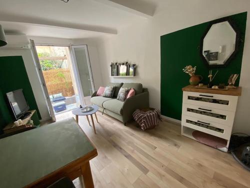 un salon avec un canapé et un miroir dans l'établissement Le Petit Vendôme avec terrasse, à Aix-en-Provence