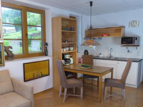 une cuisine et une salle à manger avec une table et des chaises dans l'établissement Ruhige, charmante Ferienwohnung "Im Erftal", à Eichenbühl