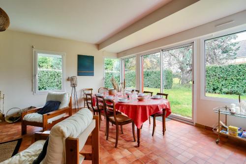 un salon avec une table, des chaises et des fenêtres dans l'établissement À 900m des plages- Maison pour 7, à Saint-Briac-sur-Mer