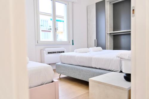 a white bedroom with two beds and a couch at Colombo - Boutique Home in Florence in Florence