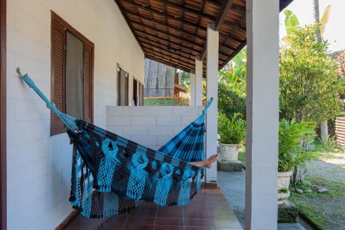 a hammock hanging from the porch of a house at Residencial Solar do Pescador in São Sebastião