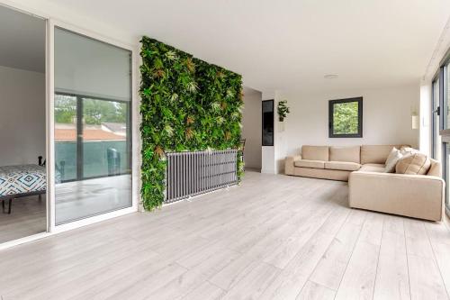 - un salon avec un canapé et un mur vert dans l'établissement Maison traversante et ensoleillé, à Aulnay-sous-Bois