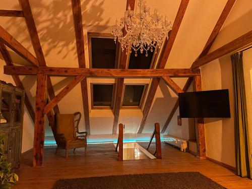 a living room with a chandelier and a tv at Quartier im Gutshaus in Wustermark