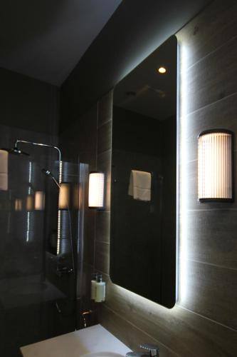 a bathroom with a large mirror and a sink at Coach & Horses Dersingham in Dersingham