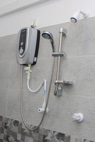 a phone is hooked up to a shower in a bathroom at Laguna Surfing Stay in Midigama