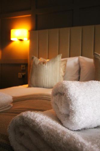 a bedroom with a bed with white towels on it at Coach & Horses Dersingham in Dersingham