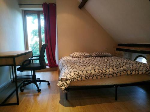 une chambre avec un lit, un bureau et une fenêtre dans l'établissement Petite maison à la campagne, à La Selle-Craonnaise