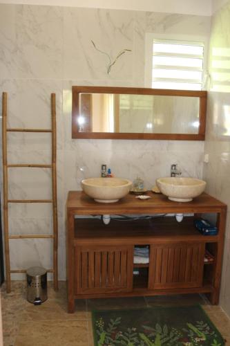 a bathroom with two sinks and a mirror at Le Chalet des Rêves Ensoleillés in Saint-François