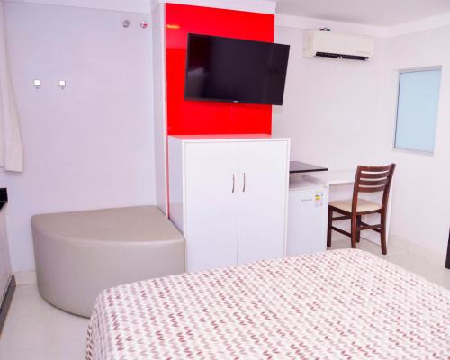 a bedroom with a bed and a tv on the wall at Hotel Sempre Executive in Salvador