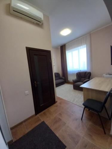 a room with a door and a table and a couch at Karavella in Mykolaiv
