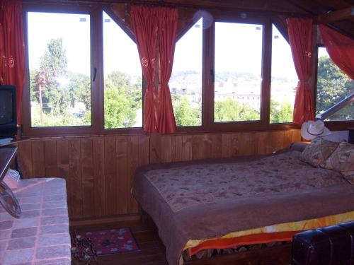 クルジュ・ナポカにあるTransylvania Cowboy Cottageのベッドルーム(窓、テレビ付)