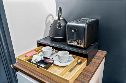 a table with two cups and a toaster on it at G Eighty Four in London