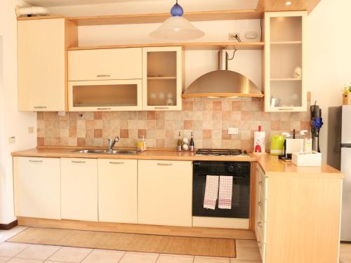a kitchen with white cabinets and a sink at Villa Turchese - private pool & jacuzzi in Sulzano