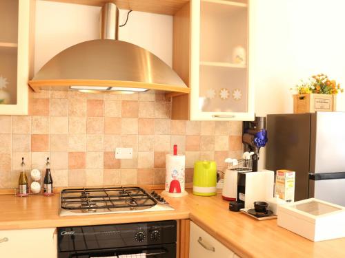 a kitchen with a stove top oven next to a refrigerator at Villa Turchese - private pool & jacuzzi in Sulzano