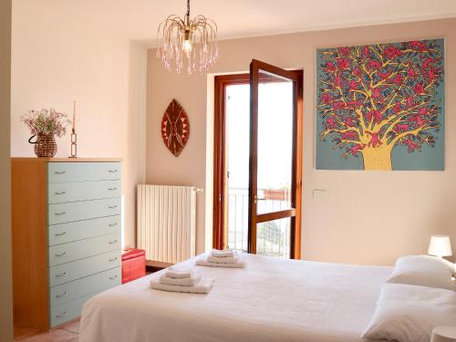 a bedroom with a white bed and a large window at Villa Turchese - private pool & jacuzzi in Sulzano