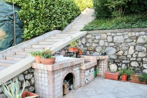 a stone fireplace in a yard with a stone stairs at Villa Turchese - private pool & jacuzzi in Sulzano