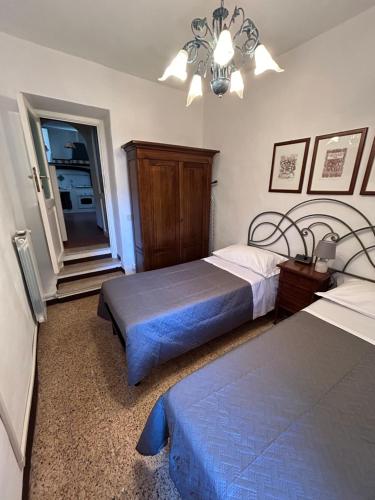 a bedroom with two beds and a chandelier at La Casetta del Vicolo in Palestrina