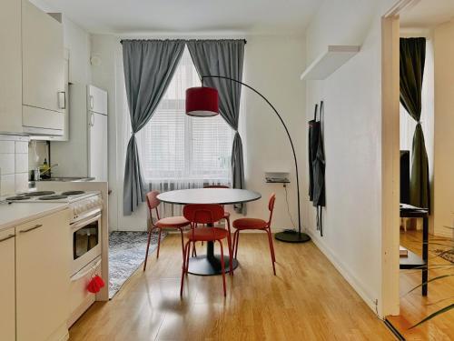 eine Küche mit Tisch und Stühlen und einem Fenster in der Unterkunft 1BR Demure Design Urban Living Space in Helsinki