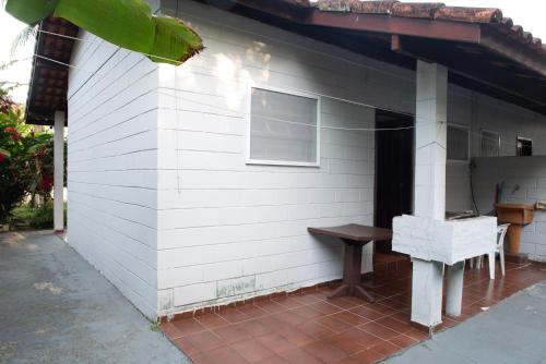 a white house with a bench on the side of it at Residencial Solar do Pescador in São Sebastião