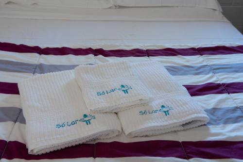 two white towels sitting on top of a bed at Residencial Solar do Pescador in São Sebastião