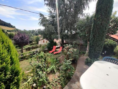 two red chairs are sitting in a garden at Maison à louer à Allègre in Allègre
