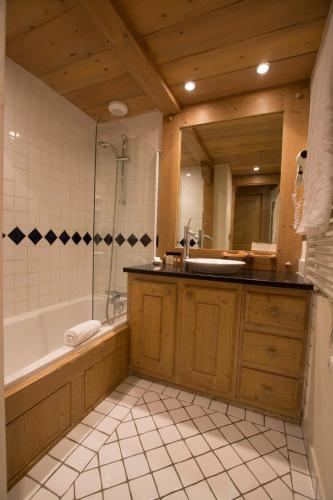 a bathroom with a tub and a sink and a bath tub at Chalet Hotel L’Ecrin in Tignes
