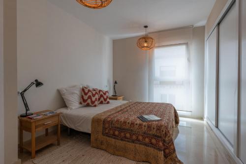 a bedroom with a bed and a table with a lamp at Casa2Iberia in Benissa