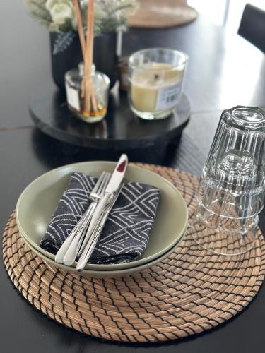 une plaque avec des ustensiles sur une table et une table dans l'établissement Exotic & Cosy room proche Roissy Cdg Airport, à Tremblay-en-France