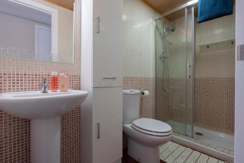 a bathroom with a toilet and a sink and a shower at Casa2Iberia in Benissa