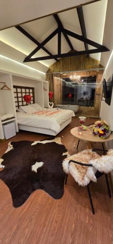 een slaapkamer met een bed en een tafel met een tapijt bij Pousada Villa Dolce Amore - Boutique Hotel in Campos do Jordão