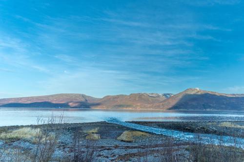 a body of water with mountains in the background at Malangen Lodge in Tromsø