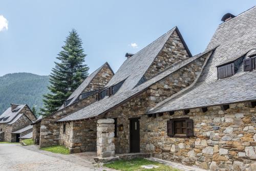 a row of stone buildings with pointed roofs at Pleta Baqueira Luxe 3 by FeelFree Rentals in Naut Aran