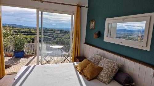 a bedroom with a bed and a balcony with a view at Rêve d'ESCAPADE chambre avec vue sublime sur les Cévennes Ardéchoises in Barjac