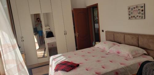 a bedroom with a bed and a woman taking a picture at Te Endriti in Shkozë