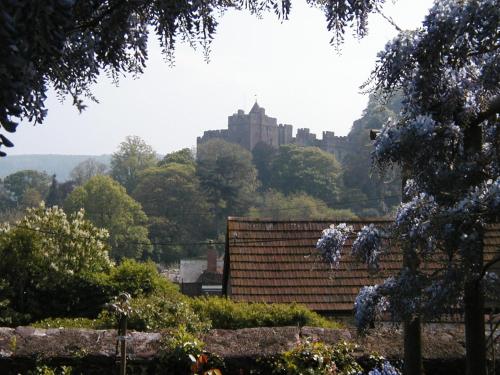 a castle on top of a hill with a house at The Linhay in Minehead