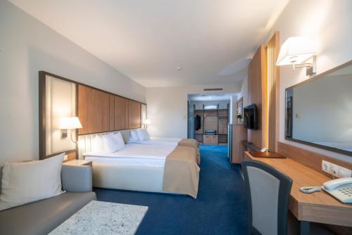 a hotel room with two beds and a flat screen tv at Legends Hotel in Sofia