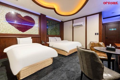 a hotel room with two beds and a table at Doksan 3S Hotel in Seoul