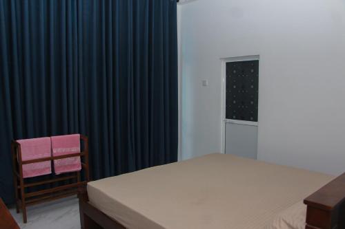 a bedroom with a bed and a black curtain at Laguna Surfing Stay in Midigama
