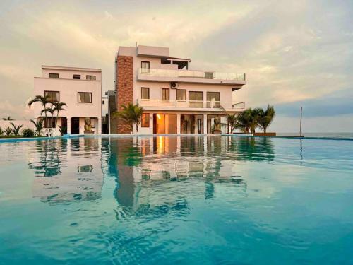 a hotel with a pool in front of a building at Villa Monterrico in La Muerte