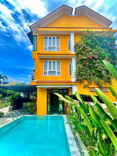 a house with a swimming pool in front of a house at Flamingo Villa Homestay - Big Rooms with Balcony - Close to Hoi An Old Town 200m & Temple Bridge - Large Outside Pool for Sun Bathing in Hoi An